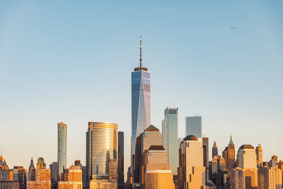 Aerial view of the Lower Manhattan financial district skyline at dusk.